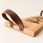 Detail van de beuken serveerplank: houten zijkant en leren handvat